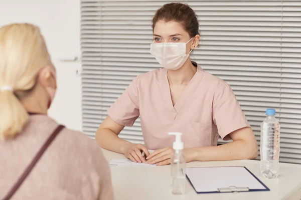 Portret Van Jonge Vrouwelijke Arts Met Masker Tijdens Het Raadplegen — Stockfoto