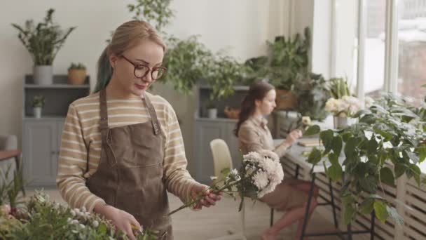 Sarışın Beyaz Kadın Çiçekçinin Gülümseyen Mezhepçilerle Çiçekleri Budayıp Bitki Dükkanının — Stok video