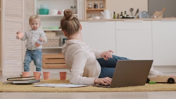 Pełne Ujęcie Młodej Zajętej Białej Matki Leżącej Podłodze Korzystającej Laptopa — Wideo stockowe