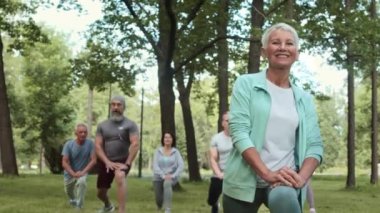 Takım arkadaşlarıyla açık havada antrenman yaparken kısa saçlı, kısa saçlı, beyaz, güzel bir kadının düşük açılı görüntüsü.