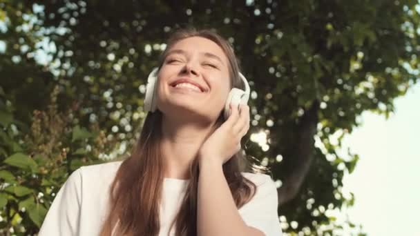 Під Низьким Кутом Радісної Молодої Кавказької Жінки Одягненої Навушники Слухаючи — стокове відео