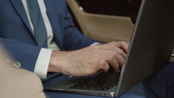 Przycięty Nierozpoznawalny Biznesmen Niebieskim Garniturze Siedzący Samochodzie Wpisujący Klawiaturze Laptopa — Wideo stockowe