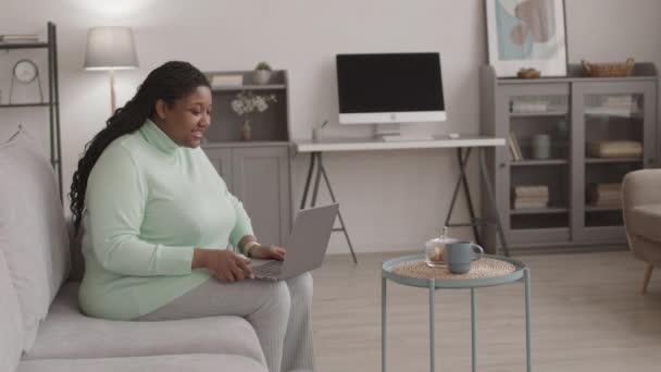 Keskikokoinen Laukaus Nuori Afroamerikkalainen Nainen Päällään Rento Vaatteita Istuu Sohvalla — kuvapankkivideo