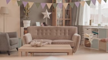 İki sevimli melez kız kardeş ellerinde yıldız uçlu ve kurdeleli oyuncak asalar, oturma odasında koşuşturuyorlar.