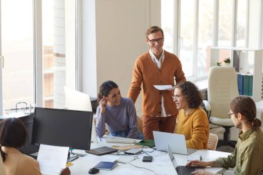 Proje tartışan ve gülümseyen genç bilişim geliştirme ekibinin portresi yazılım üretim ofisinde çalışırken, kopyalama alanı