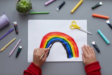 Gökkuşağını LGBTQ sembolü olarak boyayan tanınmayan bir kadının en üst görüntüsü evde otururken, boşluğu kopyala