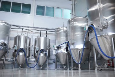 Modern endüstriyel bira fabrikasındaki içki imalathanesi ve fermantasyon tanklarının geniş açılı arkaplan görüntüsü, boşluğu kopyala