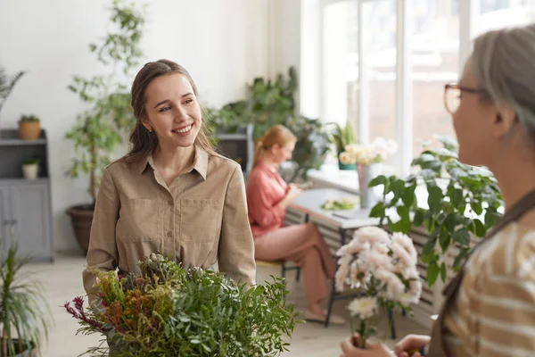 花屋で仕事を楽しみながら笑顔若い女性花屋のウエストアップの肖像画 コピースペース — ストック写真