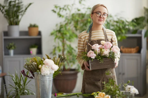 腰アップポートレートのブロンド若いです女性保持花とカメラを見ながらポーズで花ワークショップ コピースペース — ストック写真