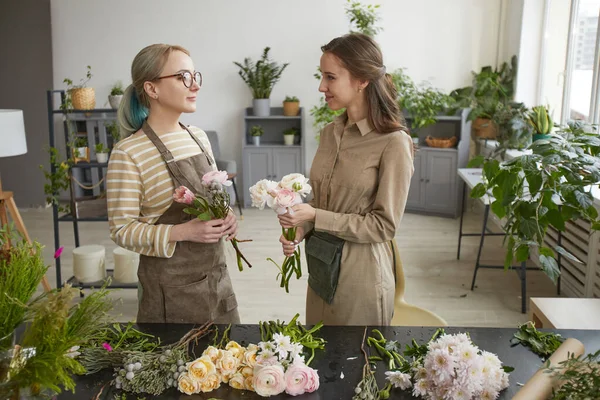 Midja Upp Porträtt Två Kvinnliga Blomsterhandlare Chatta Samtidigt Ordna Blomsterkompositioner — Stockfoto