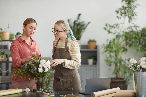 ウエストアップポートレートの2人の若い女性アレンジメント花店で作業しながら 花の組成物 コピースペース — ストック写真