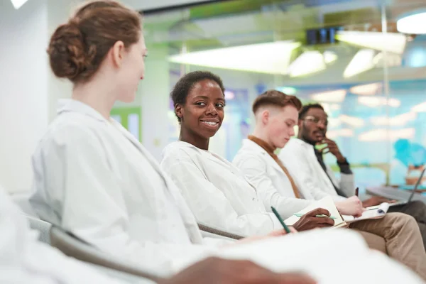 Sidovy Multietnisk Grupp Unga Människor Som Bär Labbrockar Medan Sitter — Stockfoto