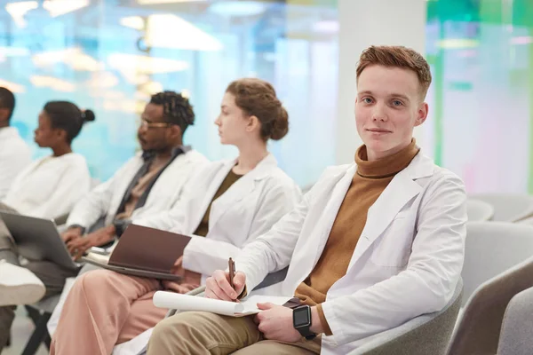 Porträtt Ung Man Bär Labbrock Och Ler Mot Kameran Medan — Stockfoto