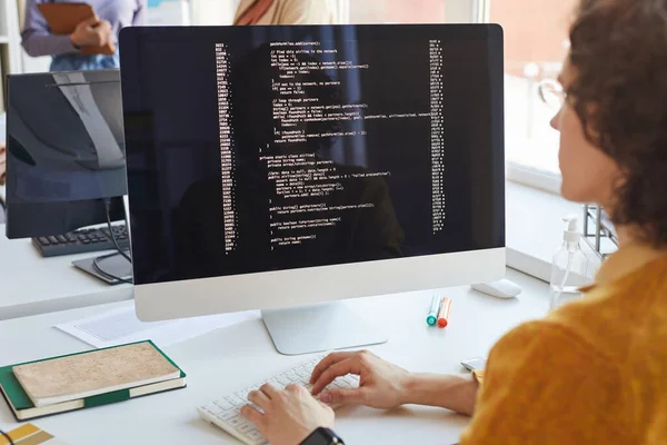 在电脑屏幕上写代码的年轻It开发人员在软件制作工作室工作时 复制空间 — 图库照片
