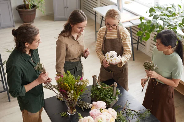 ワークショップで花の組成を作成する若い花屋のグループでの高い角度ビュー コピースペース — ストック写真