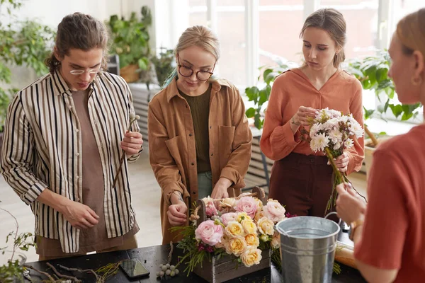 フラワーアートの授業に出席しながら 花屋のワークショップで花を配置する若い人たちの多様なグループ — ストック写真