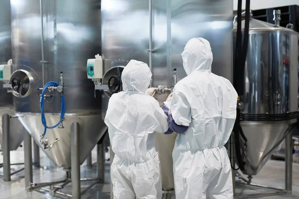 Achteraanzicht Twee Werknemers Beschermende Pakken Tijdens Het Gebruik Van Machines — Stockfoto