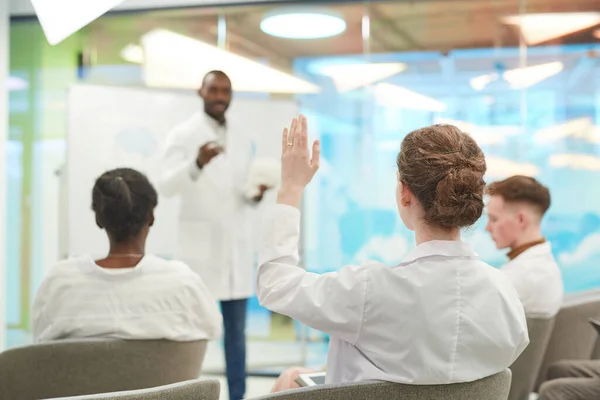 大学で医学セミナーを聞きながら手を上げる若者たちの振り返り スペースのコピー — ストック写真
