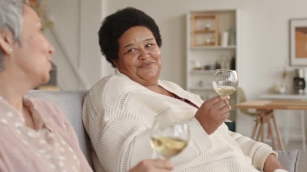 Sledovat Vlevo Veselou Africkou Ženu Usmívající Sedící Gauči Popíjející Víno — Stock video