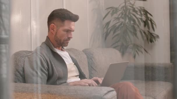 Médio Longo Bloqueado Homem Caucasiano Pensivo Sentado Sofá Digitando Computador — Vídeo de Stock
