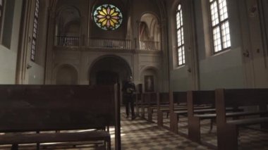 Siyah pantolon, gömlek ve beyaz yakalı genç bir Afro-Amerikan rahibin elinde İncil ile Lüteriyen kilisesinde dolaşması.