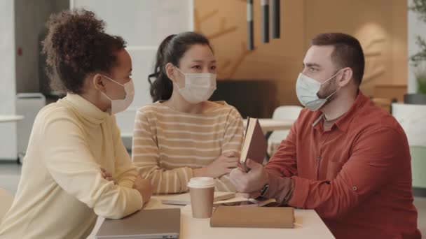 Média Jovens Colegas Multiétnicos Com Máscaras Médicas Sentados Mesa Restaurante — Vídeo de Stock