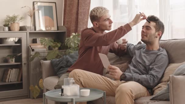 Lockdown Young Caucasian Man Blond Hair Sitting Sofa Home Applying — Stock Video