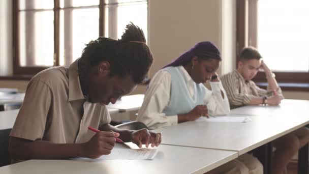 Podsvícený Záběr Studenta Africké Vysoké Školy Psaní Papíře Perem Třídě — Stock video