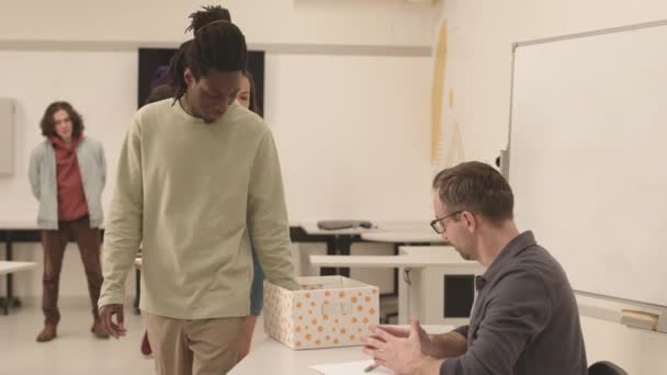 Beyaz Erkek Öğretmenin Gözlüklü Sınıftaki Masasında Oturan Çok Irklı Öğrencilerin — Stok video