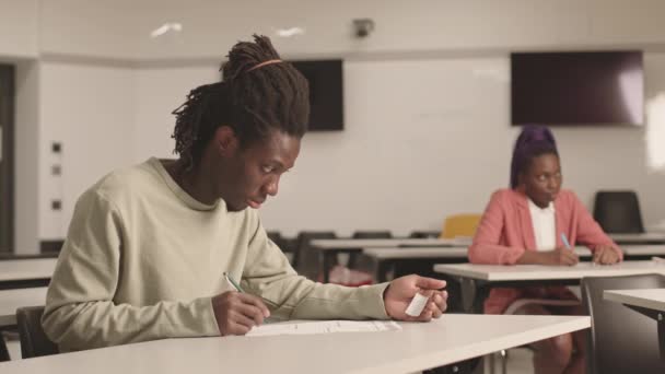Brustbild Eines Männlichen Afrikanischen Studenten Der Schulzimmer Schreibtisch Sitzt Prüfungen — Stockvideo