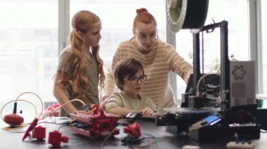 Kafkasyalı öğrenci, liseli kız ve onların genç bayan öğretmenleri dizüstü bilgisayarlarında toplandı ve robotları için hazırlanan program kod öğrencilerini analiz ettiler.