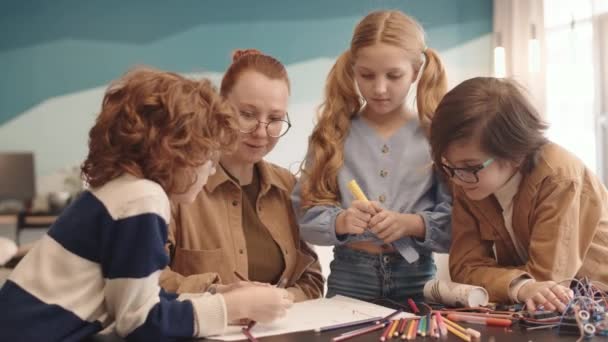 Plan Moyen Une Jeune Enseignante Deux Écoliers Une Écolière Réunis — Video