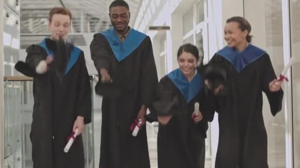 Inclinado Hacia Arriba Cuatro Diversos Graduados Con Vestidos Graduado Universitario — Vídeo de stock