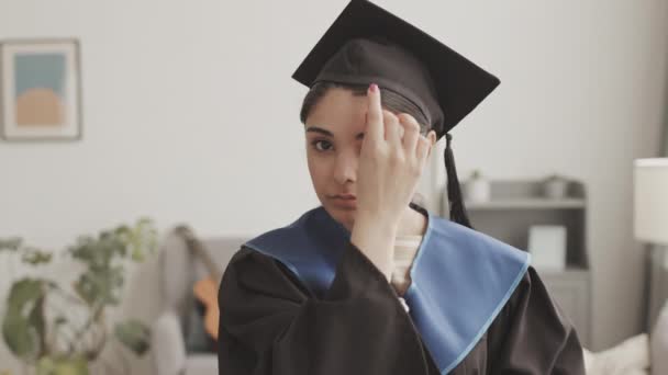 Lockdown Young Mixed Race Woman Wearing Graduation Gown Putting Hat — Stock Video