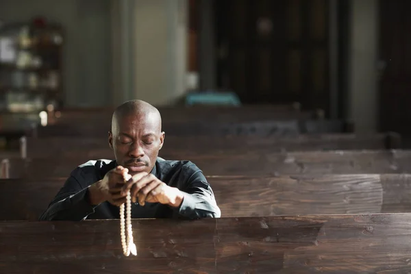 Afrikaanse Man Zittend Kerk Met Kralen Biddend Met Zijn Ogen — Stockfoto