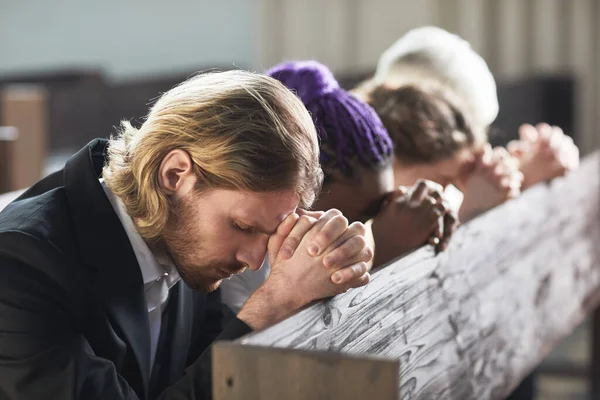 Grupa Ludzi Siedzących Rzędzie Zamkniętymi Oczami Modlących Się Wspólnie Kościele — Zdjęcie stockowe
