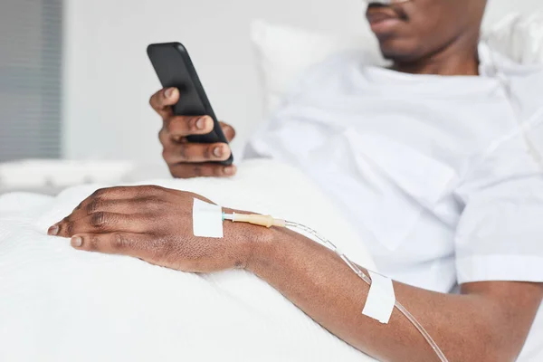 Närbild Afroamerikansk Man Sjukhussäng Och Med Hjälp Smartphone Med Fokus — Stockfoto