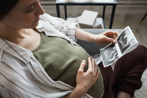 Mujer Embarazada Sentada Sofá Descansando Mirando Imagen Rayos Esperando Nacimiento —  Fotos de Stock