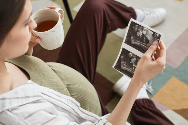 Young Pregnant Woman Enjoying Cup Tea Looking Ultrasound Her Baby — Stock fotografie