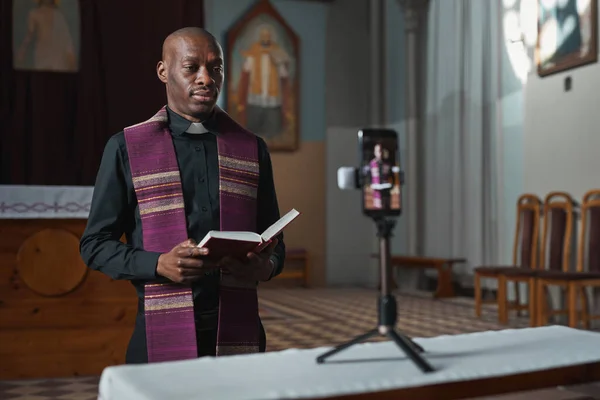 Sacerdote Africano Pie Frente Cámara Teléfono Móvil Leyendo Biblia Línea —  Fotos de Stock