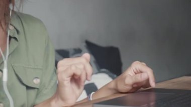 Dizüstü bilgisayarın başında durup, dinleme cihazlı kulaklık takan, konuşan, video görüşmesi yapan beyaz bir kadının yüzüne karşı durmak.