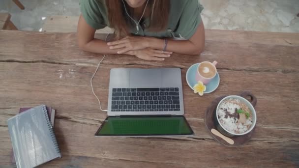 带着笔记本 咖啡杯和一碗冰沙坐在木制户外餐桌前 举行电视电话会议 — 图库视频影像