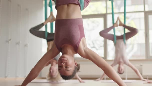 Tilting Young Mixed Race Woman Doing Aerial Yoga Upside Fabric — Stockvideo