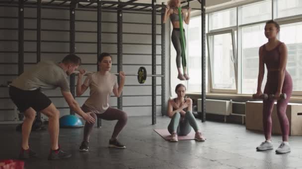 Широкий Снимок Женщин Тренирующихся Спортзале Сидящих Корточках Штангой Гантелями Сидящих — стоковое видео