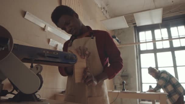 Střední Záběr Afroamerického Řemeslníka Zástěře Broušení Dřevěné Desky Hrany Pomocí — Stock video