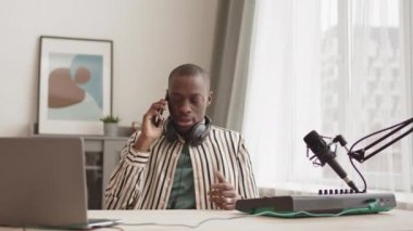 Evdeki modern Midi klavye sentezleyicisinde oturan genç erkek Afrikalı-Amerikalı sanatçıların kilitlenmesi, videolu telefon görüşmeleri sırasında bunu çalması