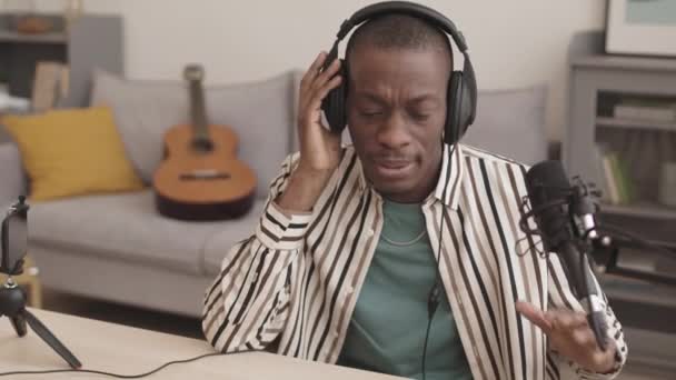 Średnie Ujęcie Młodego Afroamerykanina Słuchawkach Siedzącego Przy Biurku Studio Śpiewającego — Wideo stockowe