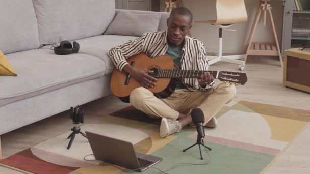 Широкий Снимок Молодого Африканского Музыканта Сидящего Полу Гостиной Стреляющего Играющего — стоковое видео