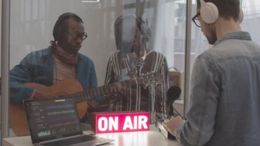 Kafkasyalı erkek ses mühendisinin Dave 'de çalışırken Afro-Amerikan müzik grubu profesyonel stüdyoda yeni single kaydediyor.