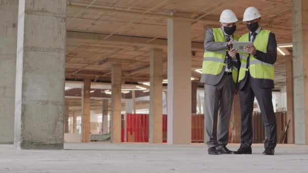 Plano Completo Dos Supervisores Construcción Masculinos Con Máscaras Faciales Chaleco — Vídeos de Stock